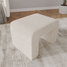 a white bench sitting on top of a rug in a living room next to a potted plant