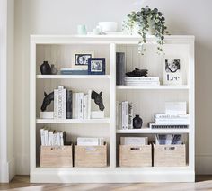 a bookshelf filled with lots of books on top of a hard wood floor