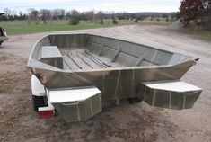 a large metal boat sitting on top of a dirt field