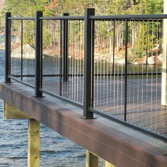 a wooden dock with metal railings and water in the backgroung area