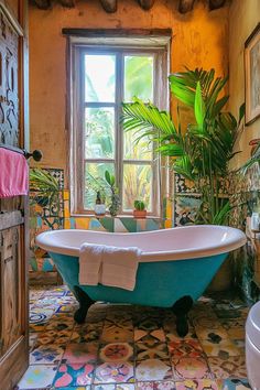 a bathroom with a claw foot tub and potted plants