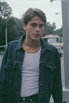 a young man standing in front of a street sign