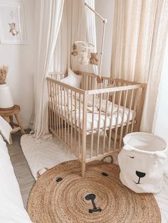 a baby's room with a crib, rug and teddy bear bedding