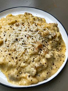 a white plate topped with macaroni and cheese covered in grated parmesan