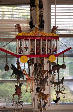 a wind chime with many different animals hanging from it's sides in front of a window