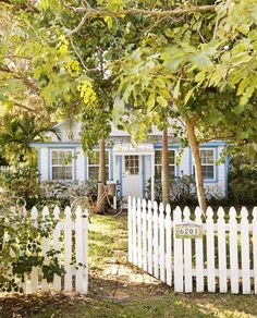 a white picket fence in front of a blue house