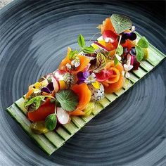 a plate that has some kind of food on top of it with leaves and flowers