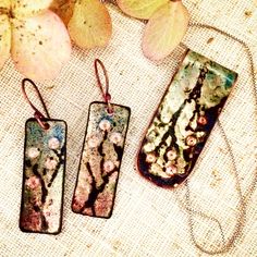 three rectangular pendants with flowers on them