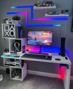 a white desk with a computer on it in front of a purple and blue wall