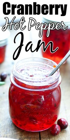 cranberry hot pepper jam in a glass jar with a spoon on the side