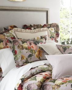 a bed with floral comforter and pillows