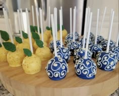 there are many blue and white candies with green leaves on the sticks in front of them