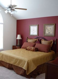 a bedroom with red walls and gold bedding