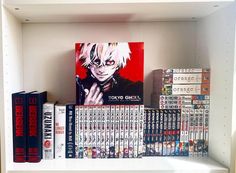 a book shelf filled with books and anime covers on top of eachother's shelves