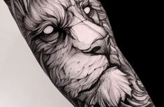 a man's arm with a black and white tattoo of a lion on it