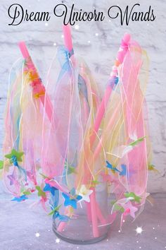 three pink and blue toothbrushes sitting in a cup with streamers on it