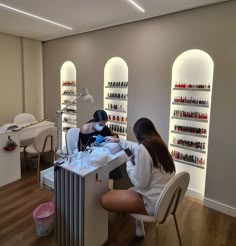 two women sitting at a counter in a nail salon