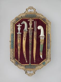 three different types of knifes are in a gold and red frame with white handles