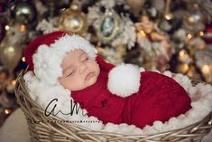 a baby wearing a santa hat sleeping in a basket