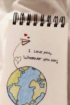 a notepad with a drawing of the earth on it and an airplane flying over it