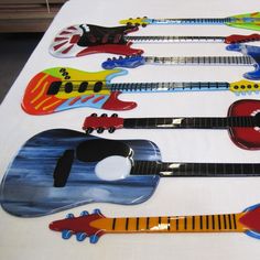 a table topped with lots of different types of guitar shaped magnets on top of each other