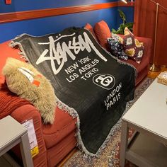 a couch with a blanket on it in a room that has blue walls and red furniture