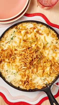 a skillet filled with food sitting on top of a red and white place mat