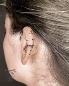 a woman's ear with an arrow tattoo on it