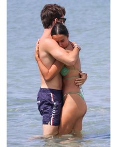 two people in the water hugging each other