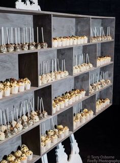 a shelf filled with lots of cupcakes on top of wooden shelves next to each other