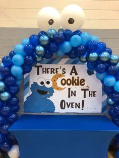 there's a cookie in the oven sign surrounded by blue balloons and white balls