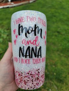 someone holding up a glittered cup with the words mom and nana written on it