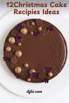 a cake with chocolate frosting and nuts on top, sitting on a white plate