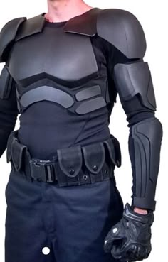 a man in a batman costume is posing for the camera with his hands on his hips