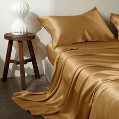 an image of a bed setting with sheets and pillows on the side table next to it