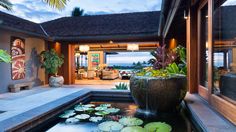 an outdoor living area with water lilies in the pond and plants on the patio