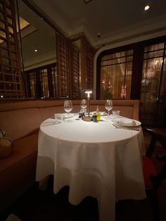 the table is set for two with wine glasses on it, and there are candles in front of them