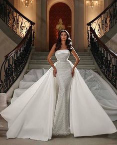 a woman in a wedding dress standing on some stairs