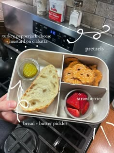 a person is holding a tray with food in it and labeled on the top side