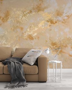 a couch with a blanket on it in front of a wall that has gold paint