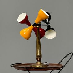 an old fashioned lamp with three different colored lamps on it's base and one light turned off