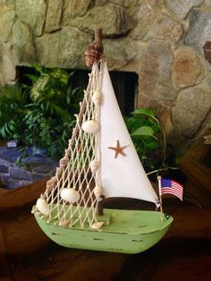 a small sailboat is sitting on a table next to a fire place and rocks