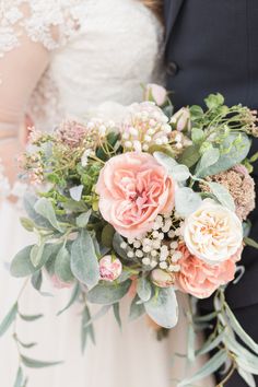 the bride and groom are holding their bouquets