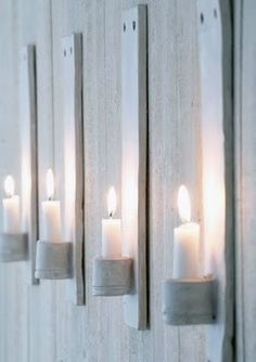 several lit candles are hanging on the wall