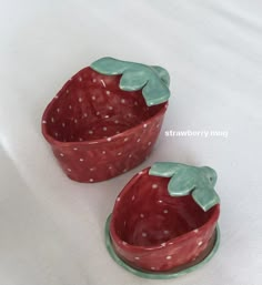 two strawberry shaped dishes sitting next to each other