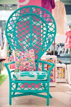 a blue chair sitting on top of a tile floor next to a pink and white wall