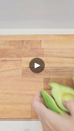 someone is peeling an avocado on a cutting board with the video below it