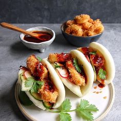 some food is sitting on a plate with dipping sauces in the bowl behind it