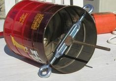 a large metal barrel sitting on top of a wooden floor next to a pair of pliers