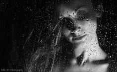 a black and white photo of a woman in the rain with her eyes covered by water droplets